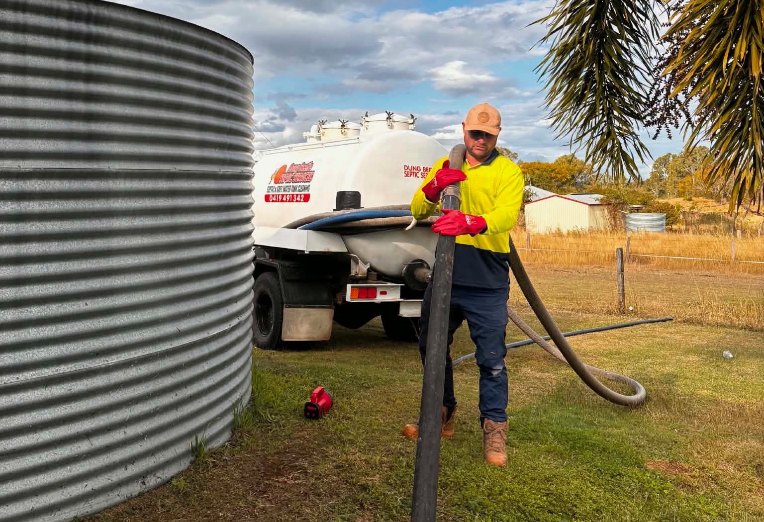 Dung Beetle tanker on site with the suction hose run into a septic tank on a rural block near Bundaberg